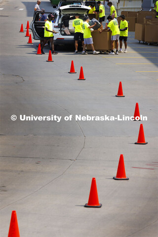 Traffic cones line the path to the student move-in team behind University Suites. Suites move-in. Au