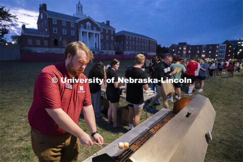 Senior residence director Dan Hudson (left) roasts marshmallows over a fire to be made into s’more
