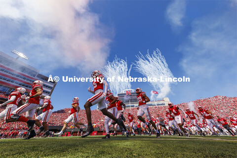 The Nebraska football team runs onto the field as fireworks go off in the background. Nebraska footb