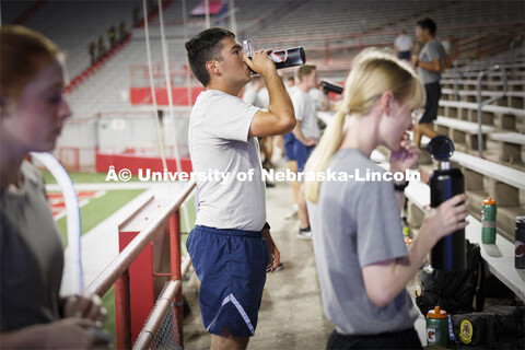AFROTC cadet Wyatt Christensen gets a drink in between climbs. 9/11 stair climb in Memorial Stadium 