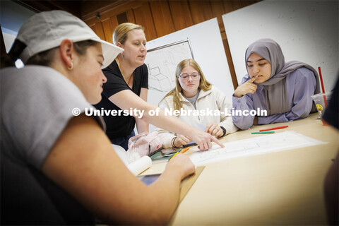 Students listen as Sonya Grace Turkman, Assistant Professor - Interior Design, critiques their proje