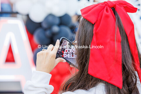 A student uses their phone to take a photo of the Cornchella sign. 2024 Homecoming celebration. Octo