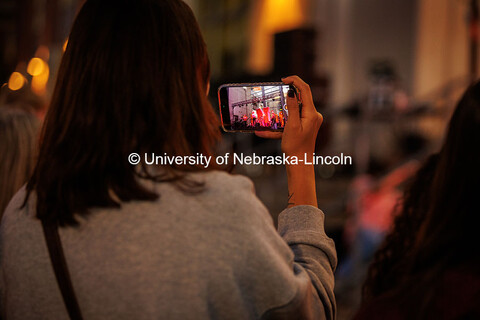 A student takes a photo with their phone at the 2024 Battle of the Bands. 2024 Homecoming celebratio