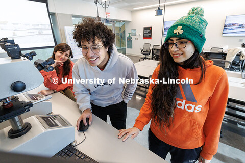 Freshman Ahmed Salem (center), and graduate student Sahar Beigzadeh (right) look at data as they run