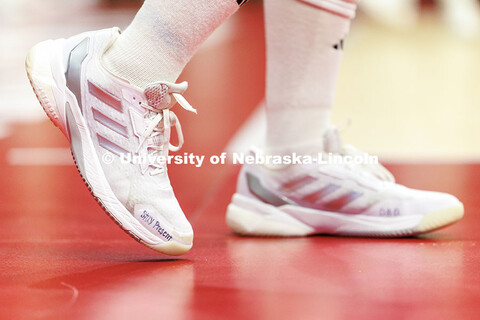 Nebraska’s Lexi Rodriguez warms-up wearing shoes with the phrase ‘Stay Present’ written on the