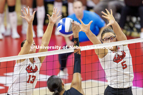 Nebraska’s Merritt Beason (left) and Rebekah Allick (right) attempt to block the ball during round