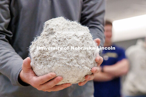 An engineering student holds what remains of a concrete ball during the Concrete Bowling Competition