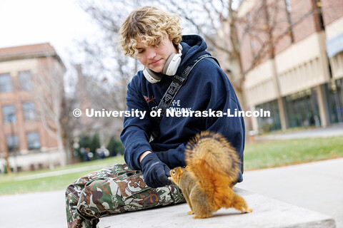 Dalton Dailey, junior, feeds squirrels outside of Love Library. December 17, 2024. 