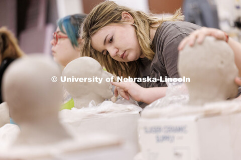 Emily Zimmerman, sophomore Art major, models her clay head during her Beginning Sculpture class insi