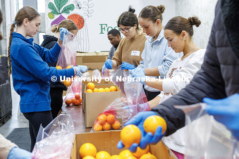 University of Nebraska–Lincoln students place oranges into bags during SLICE’s Engage Lincoln vo