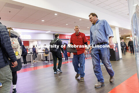 Cory Densberger, left, Hospitality Service Associate, talks with Brian Madsen as he collects food tr