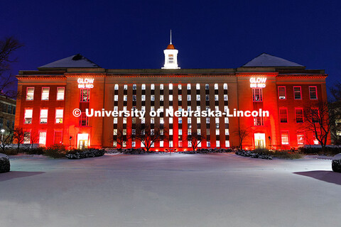 Love Library is lit up in red with gobos projected on the front saying, “Glow Big Red”. Glow Big