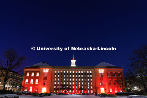 Love Library is lit up in red with gobos projected on the front saying, “Glow Big Red”. Glow Big