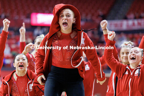 Members of the women’s gymnastics team cheer as Whitney Jencks, not pictured, sticks the landing o