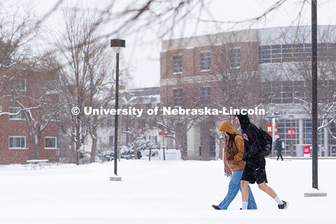 The snow falls as students cross campus near the Jackie Gaughan Multicultural Center. Snow on City C