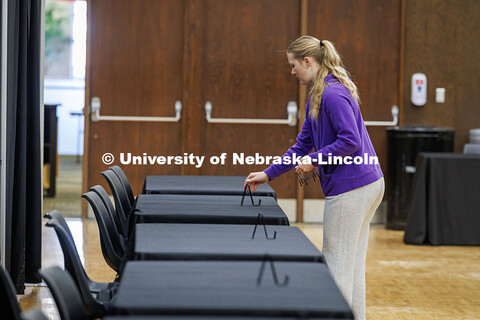 Kallie Dodds, a Junior Marketing major sets up plate stands on tables in preparation for the Career 