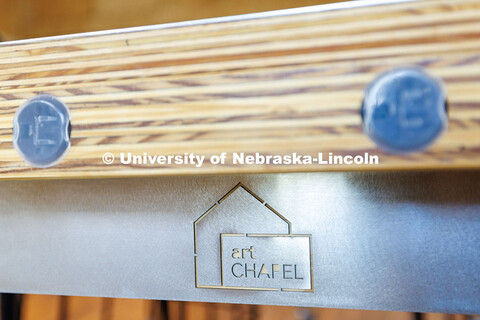 The Art Chapel logo engraved on the side of a table. Art Chapel. December 9, 2024. 