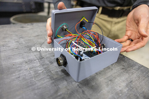 Riley Reynolds, a UNL alumnus and surgical robotics engineer, displays the control box portion of hi