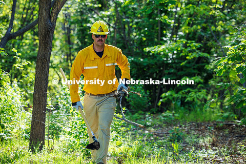 Sam Morrow, a senior Grassland Systems major, carries sticks over to cover the fireline the class cr