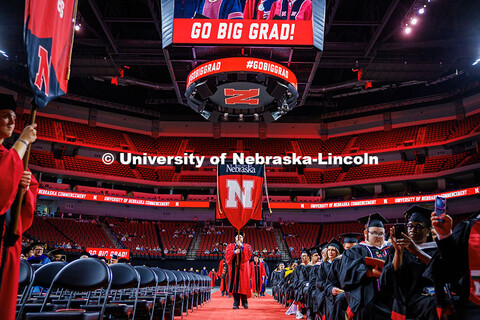 Faculty members march carrying the gonfallons into the 2025 Spring Graduate Commencement Ceremony in