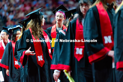 Graduates chat in line during the morning commencement ceremony processional into Pinnacle Bank Aren