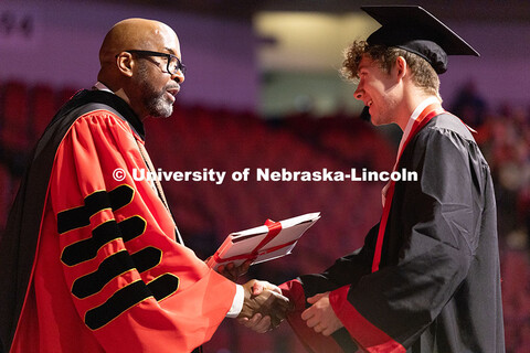 A student shakes hands with Chancellor Rodney D. Bennett before receiving his diploma at the afterno
