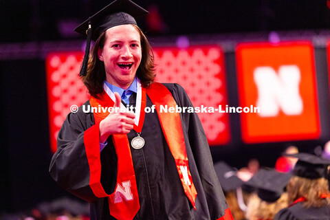Computer Science major McKellan Clarke gives a thumbs up after receiving his diploma at the Universi