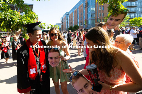 Josh Donahue's family hold cutout photos of his face outside of Pinnacle Bank Arena to make it easie