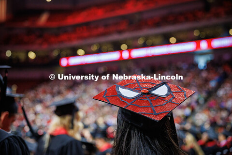 A graduating senior wears a decorated Spiderman-themed grad cap during the May 2025 Commencement Und