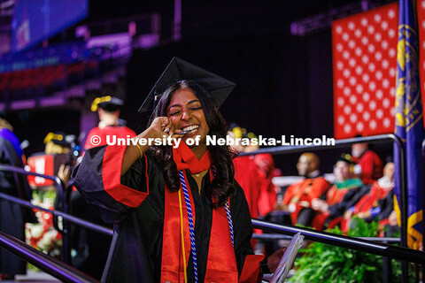 Psychology and Management major, Kelsey Kurian, bites her medal after receiving her diploma. May 202