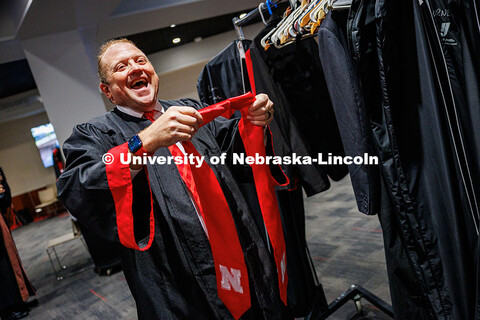 Corrie Svehla, the Assistant Director of Special Events, gets ready for his graduation behind the sc