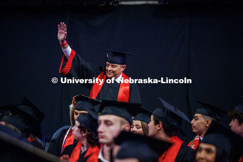Corrie Svehla, the Assistant Director of Special Events, raises his hand while standing up as he’s