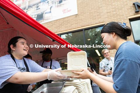 Aubrey Wyatt hands a to-go container of ribs to Minji Kang, a technician in the Department of Plant 