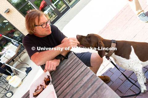 Andy Agena gives Gaspard, a French pointer, a taste of his smoked ribs at the first of East Campus D