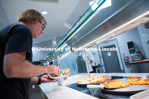 Andy Agena, who works in IT at Barkley Memorial Center, grabs a slice of pizza in the East Campus Di