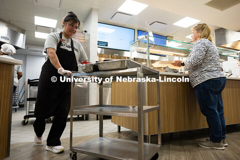 Marilou Wyatt, East Campus Dining Services production manager, pushes a cart with smoked chicken and