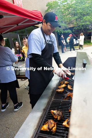 Franklin Yankton smiles as he flips chicken and ribs on a grill outside of the East Campus Dining Ce