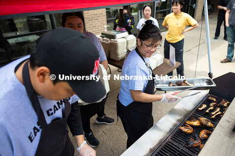 Marilou Wyatt, East Campus Dining Services production manager, uses tongs to put pork ribs on the gr