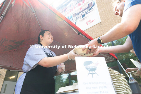 Aubrey Wyatt hands a customer their order during East Campus Dining Service's first grill outs event