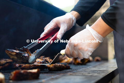 Chicken and ribs char on the top of a large propane grill outside of Nebraska East Union. East Campu