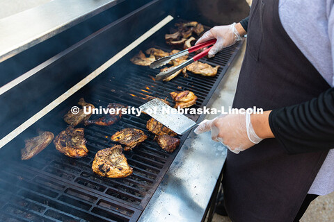 Chicken and ribs char on the top of a large propane grill outside of Nebraska East Union. East Campu