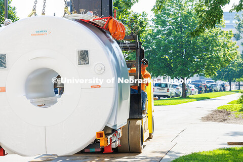 Workers from Customized Rigging use a crane to lift the new MRI scanner into Memorial Stadium. The n