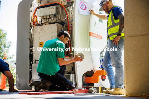 Workers from Cassling install wheels on the tools that will help them pull the new MRI scanner into 