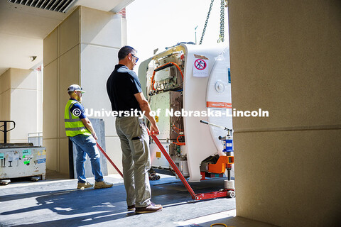 Jay Daniels (left) and Donovan Lempka from Cassling pull the MRI scanner closer to the room where it