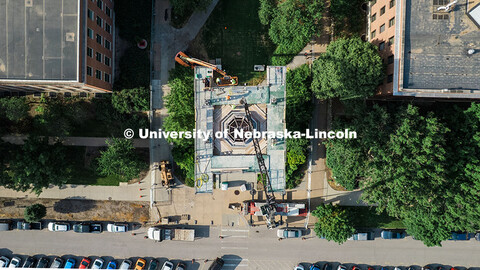 Construction workers stand on scaffolding near the top of Mueller Tower. The tower is undergoing a r