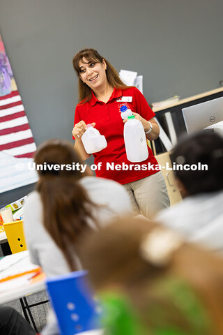 Zahraa Rida, a Lincoln-Lancaster County Extension assistant, demonstrates milk containers with diffe