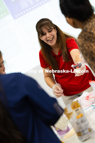 Zahraa Rida, a Lincoln-Lancaster County Extension assistant, hands a fruit, granola and yogurt parfa