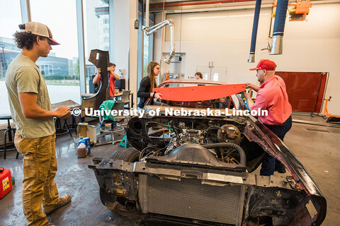 The UNL Figure 8 Racing Team attaches the dashboard to their 1980 Pontiac Firebird inside the Kiewit