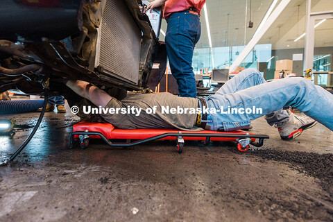 Ian Gouldie, a UNL robotics engineering major, works underneath the UNL Figure 8 Racing team car ins