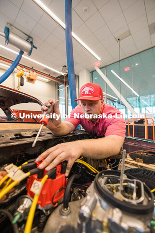 Jace Grunden, agricultural engineering major, works on a 1980 Pontiac Firebird inside the Kiewitt Ha